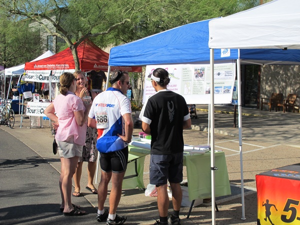 Photo of our exhibit with the 2B2R banner and Tauru and Christi talking to people.